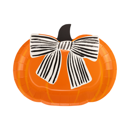 Pumpkin-shaped paper plate with a black and white bow on a white background