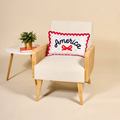 Chair with a decorative throw pillow featuring the word 'America' on a beige background