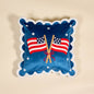 Decorative pillow with American flags and a bow with scalloped edges