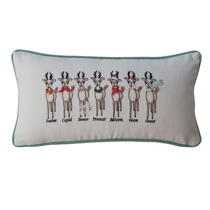 Santa’s Reindeer embroidered Christmas lumbar pillow with festive reindeer, green piping, and a neutral cotton background.